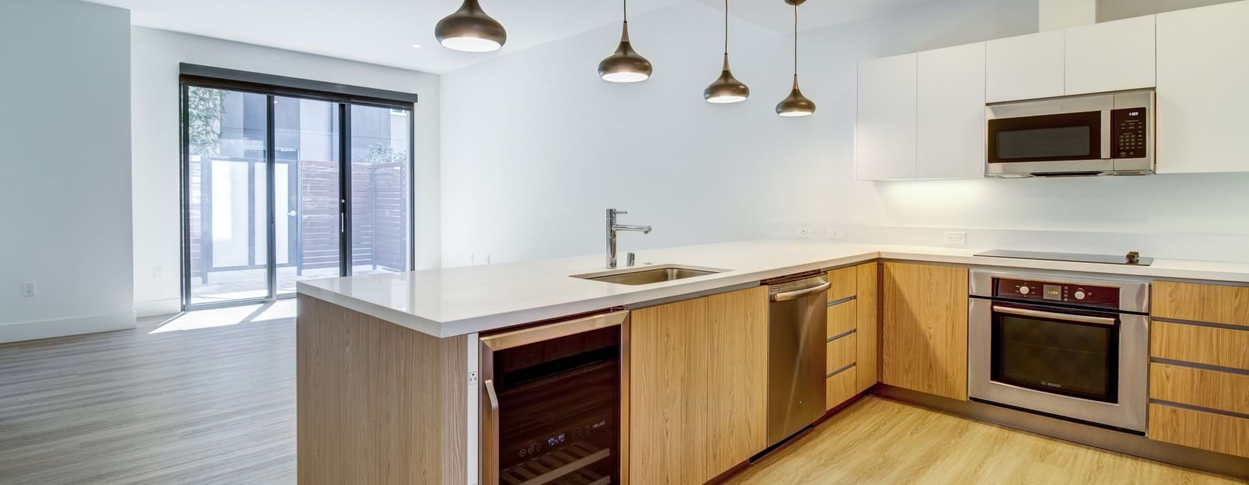 Modern kitchen inside a luxury live/work townhome at Levare featuring quartz countertops, stainless steel appliances, wood cabinetry, and an open-concept layout in San Jose.