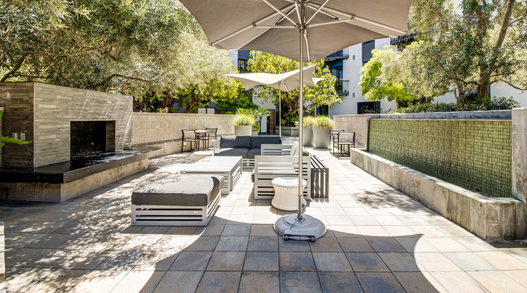 A Serene Outdoor Court Yard with Lounge Chairs and a Fireplace